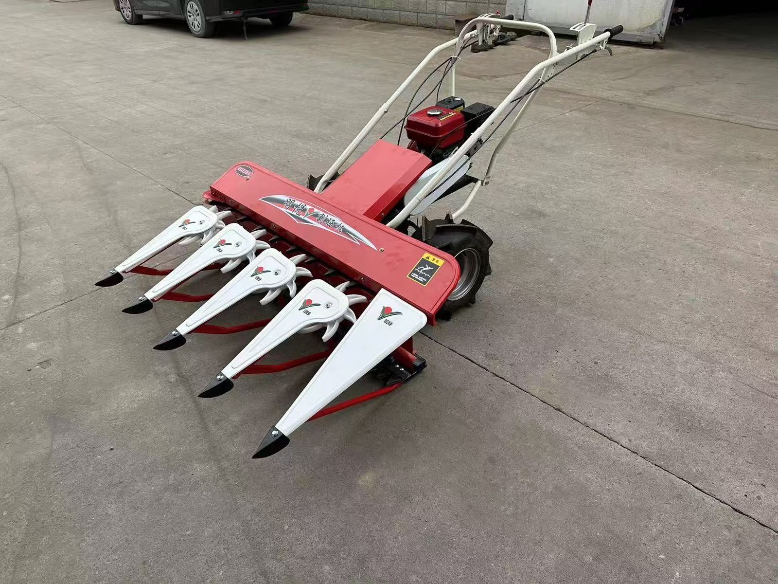 Red walk-behind harvesting machine viewed from the side